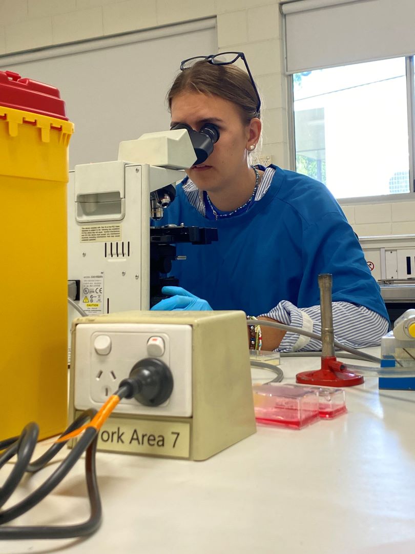 Laura using a microsope in the lab