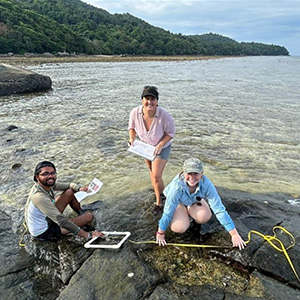 Three JCU students conducting scientific measures in the ocean