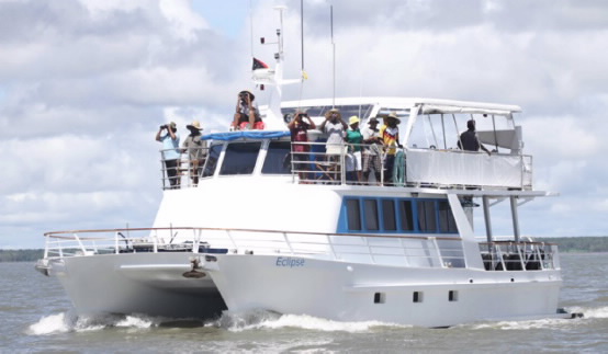 A wide view of the research vessel with people looking for dolphins