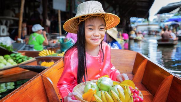 Thai girl on a boat selling fruit