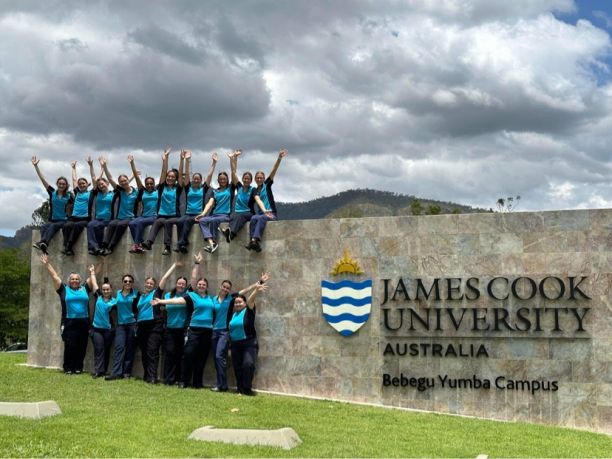 Kira with her midwifery cohort gathered around the J.C.U. Townsville sign. 