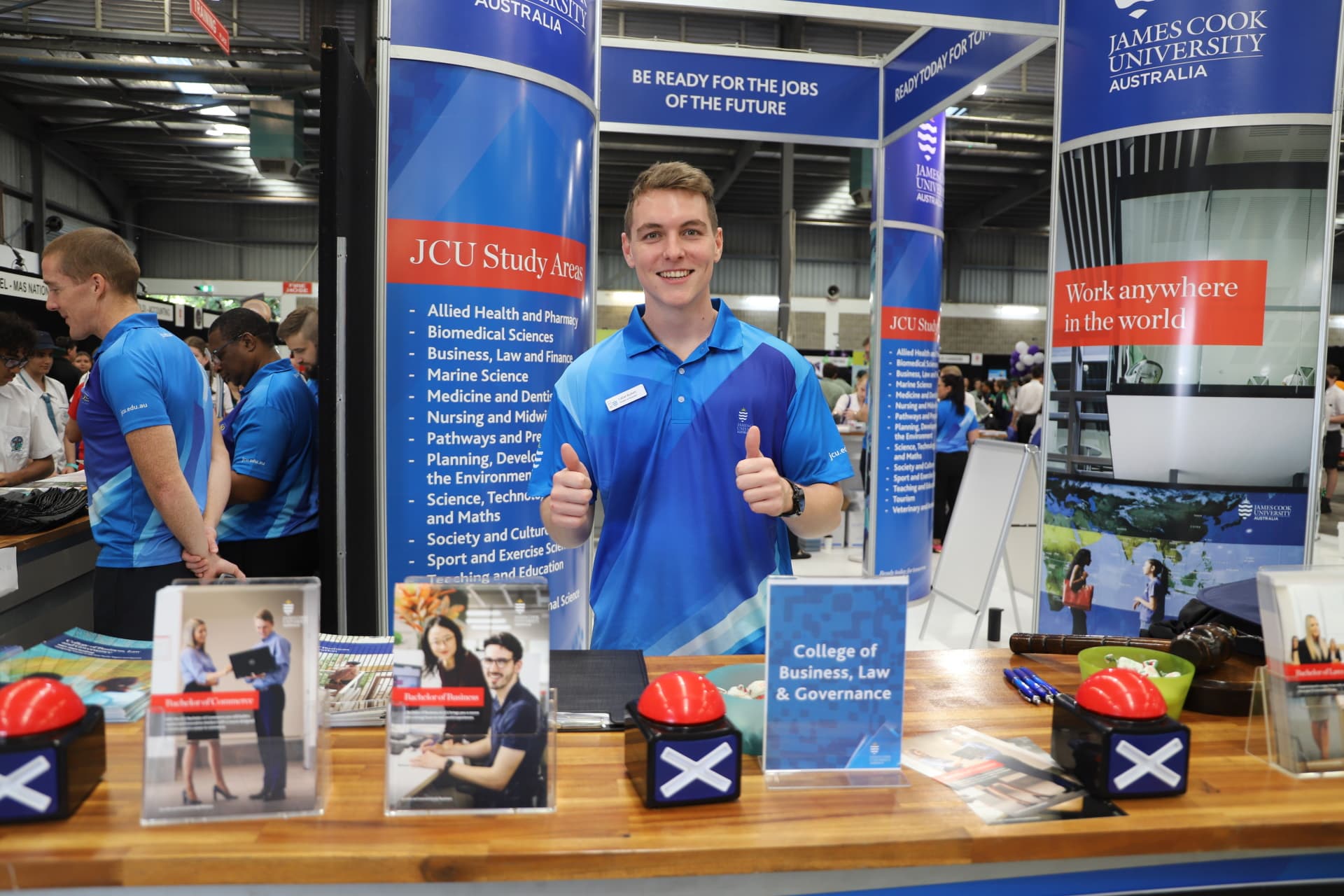 JCU Student ambassador standing behind a booth at the cairns career expo. 