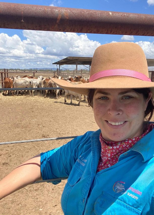 JCU Alumni and veterinarian Regan Lynch smiling and standing in front of a cattle yard. 