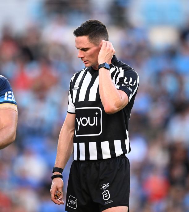 Wyatt Raymond listens to sideline office while officiating an NRL game. 