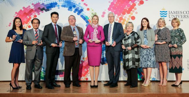 10 of the recipients stand on stage holding their awards