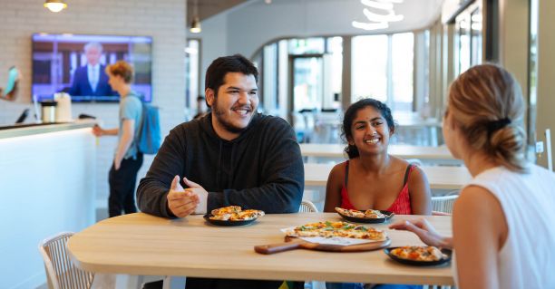Students talking together whilst eating a meal
