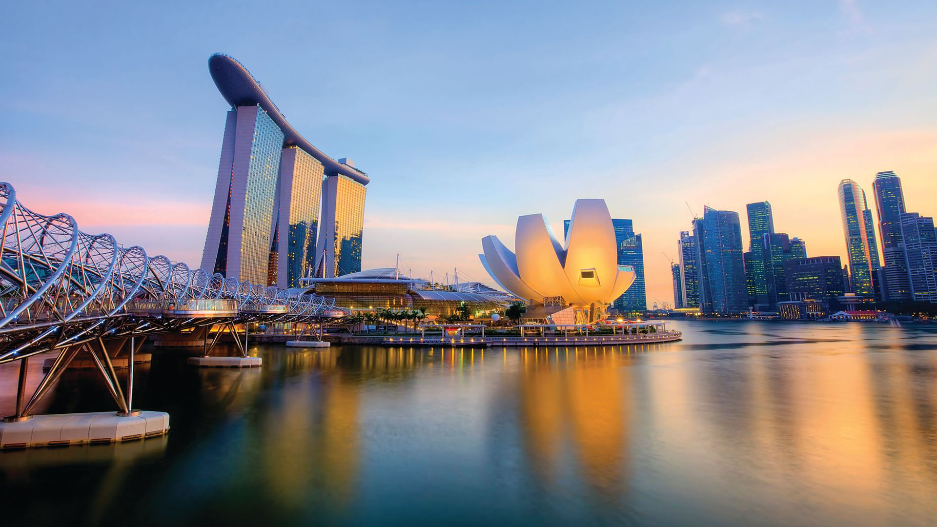 The harbor in Singapore at sunset, with architecture highlighted by sunrays. 
