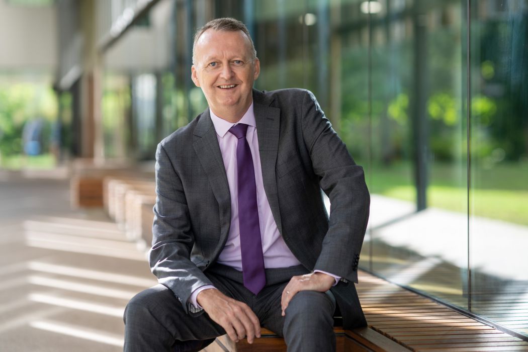 JCU Vice Chancellor and President Professor Simon Biggs seated outside the Education Central Building at the JCU Townsville, Bebegu Yumba campus, Douglas