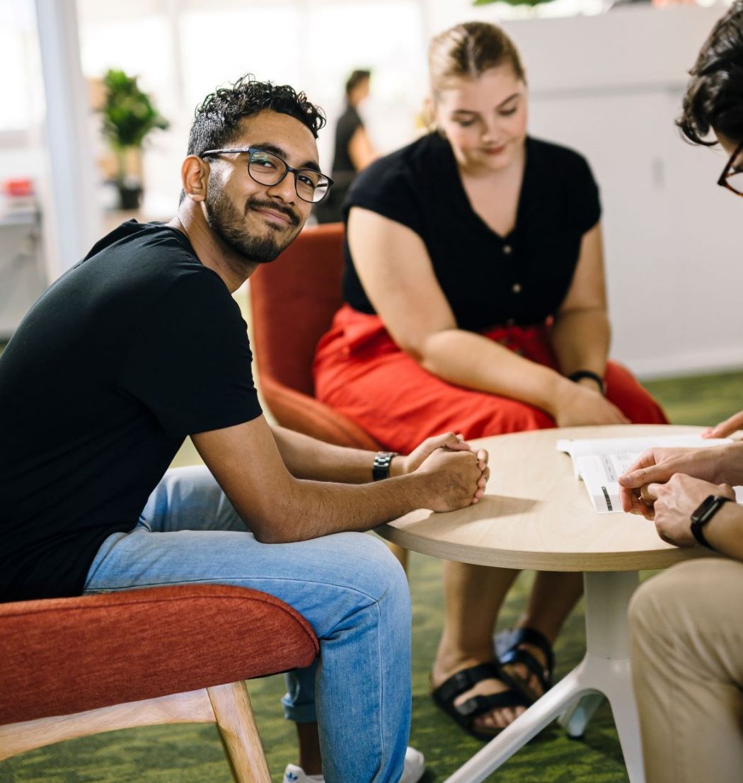Siddarth Roche sitting at a table with a group member