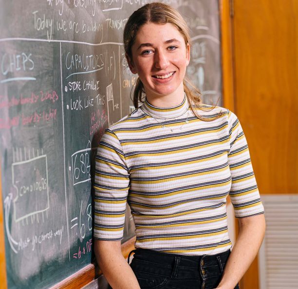 Mikala Wright standing next to a blackboard. 