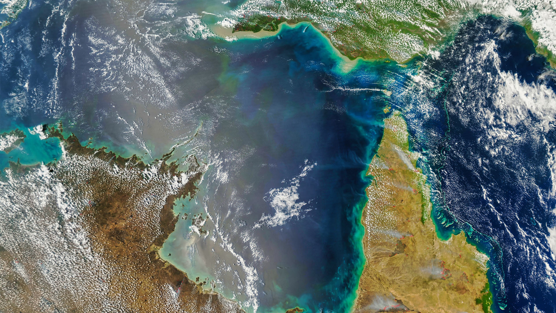 A satellite image of the tip of Australia and clouds over the ocean. 