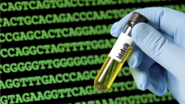 A gloved hand holds a small sample tube with yellow liquid inside, against a black background with green text on it.