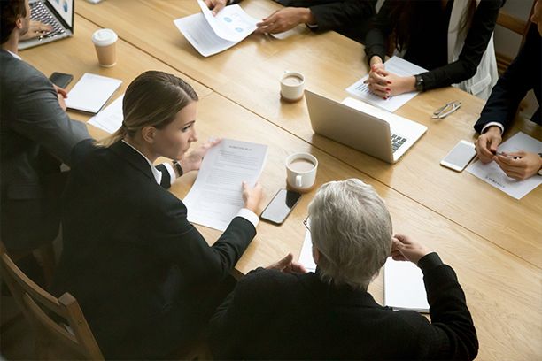 Businesspeople discussing deal details at group meeting