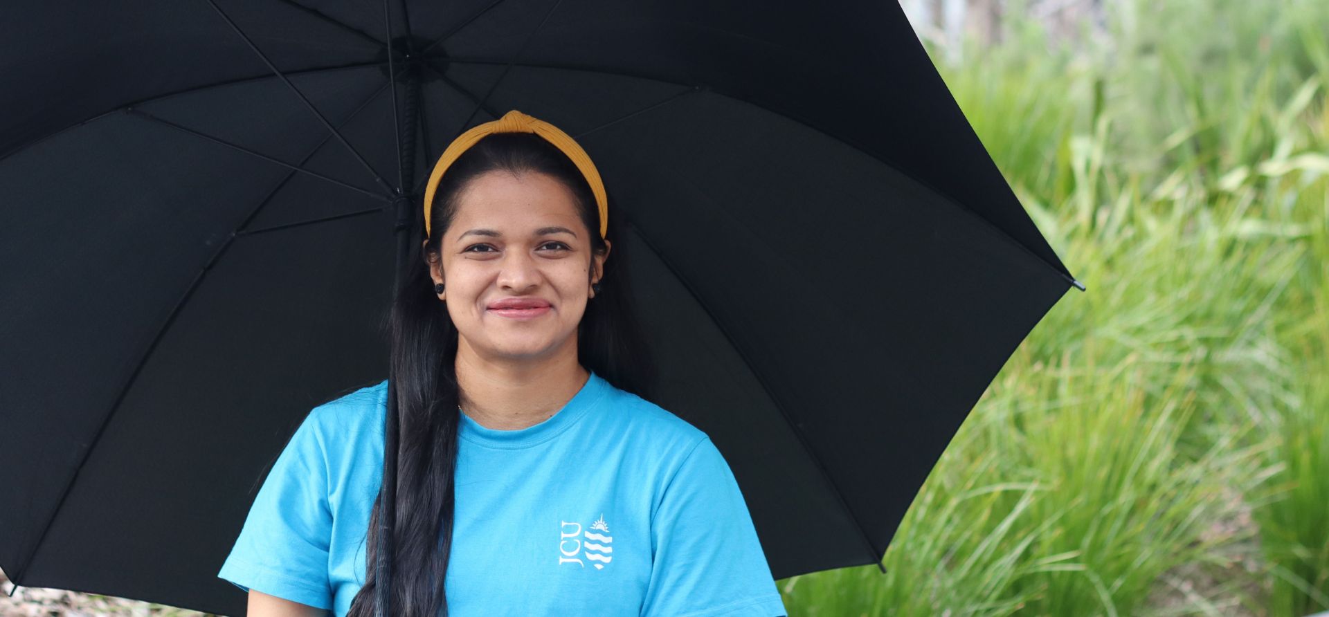 Neethu Madhukumar sheltering under an umbrella