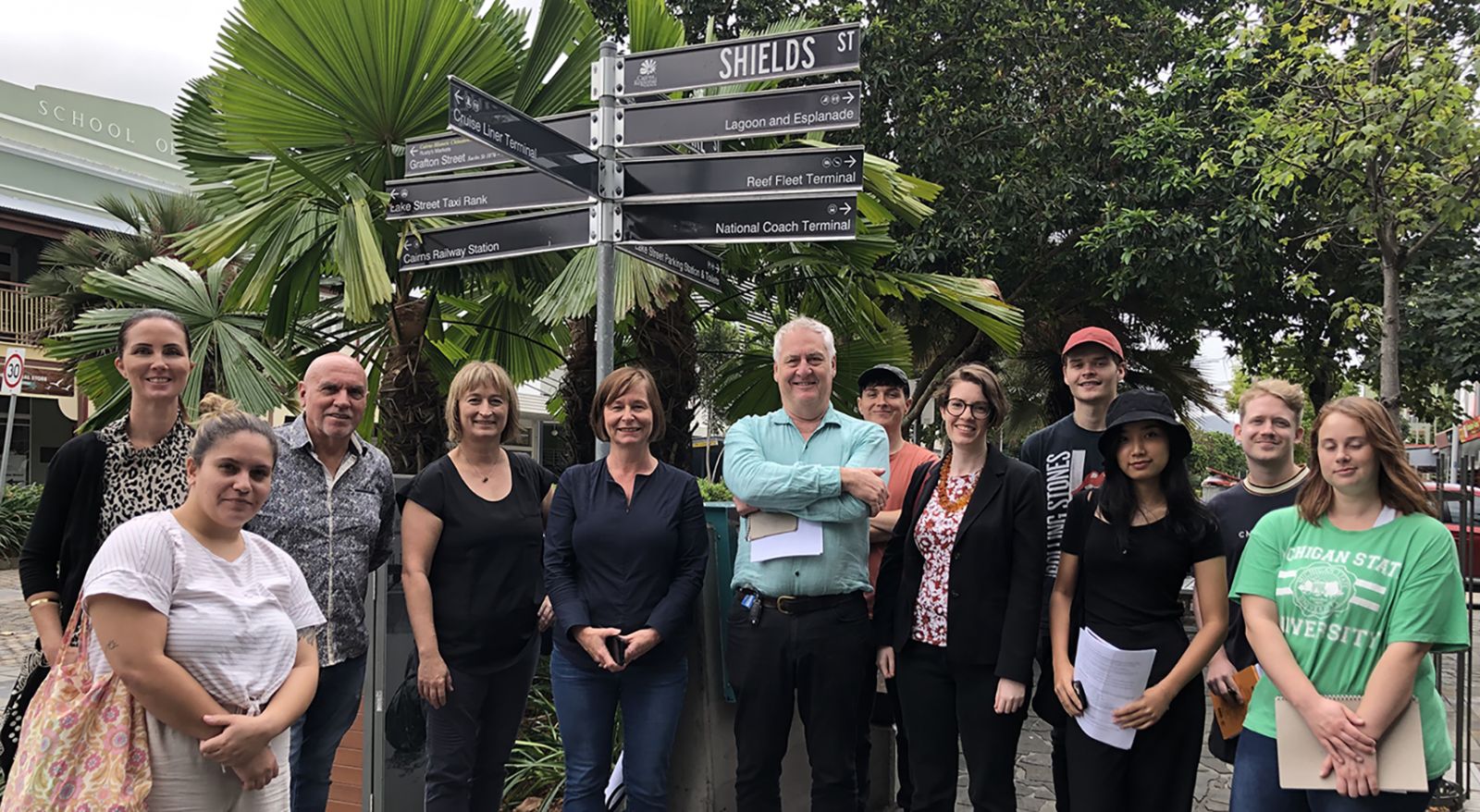 Students and advisors grouped under a cluster of street signs