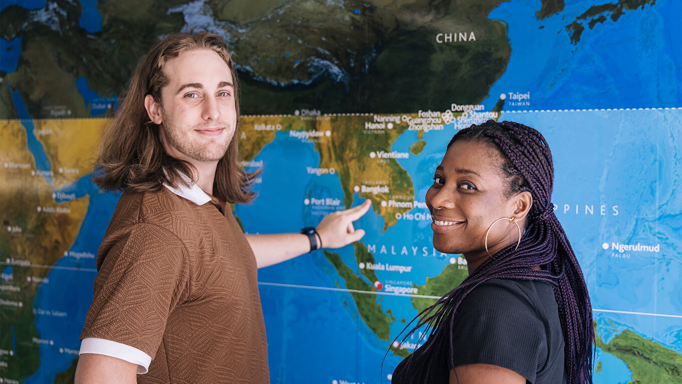 Student point to a world map