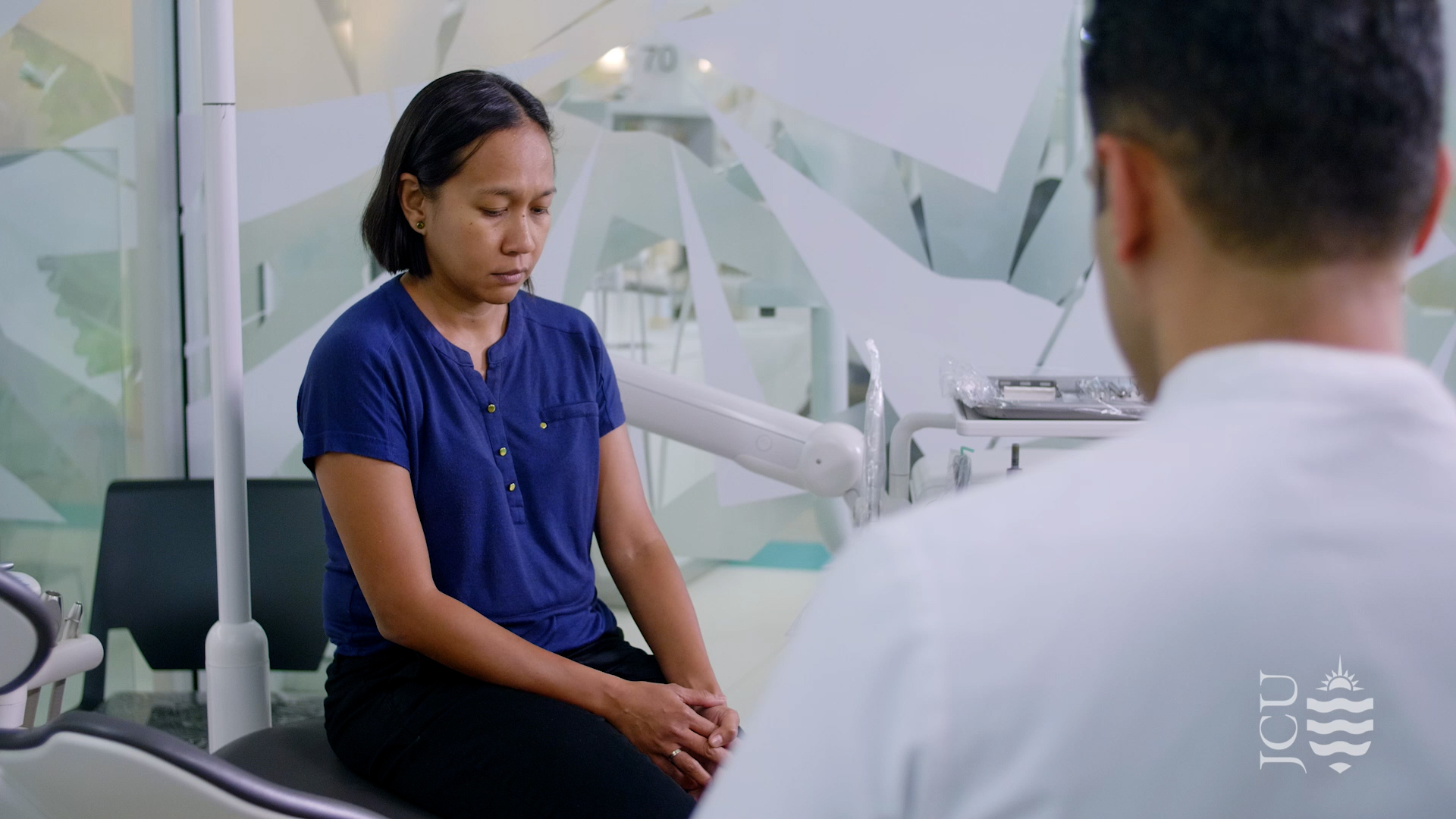 woman looking worries while dentist talks to them. 