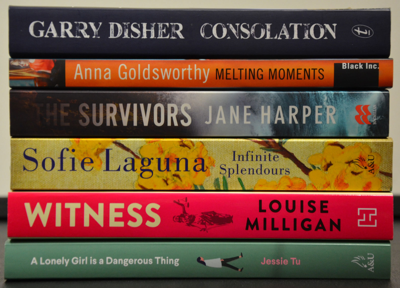 Shortlist in a book stack, top to bottom: Consolation, Melting Moments, The Survivors, Infinite Spendours, Witness, A Lonely Girl is a Dangerous Thing