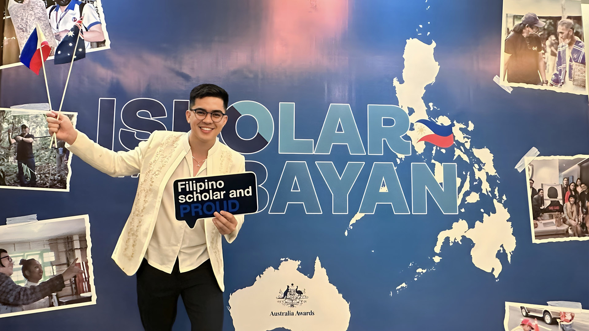 JCU Master of Science international student Christian Gino stands in front of an Australia Awards banner. 
