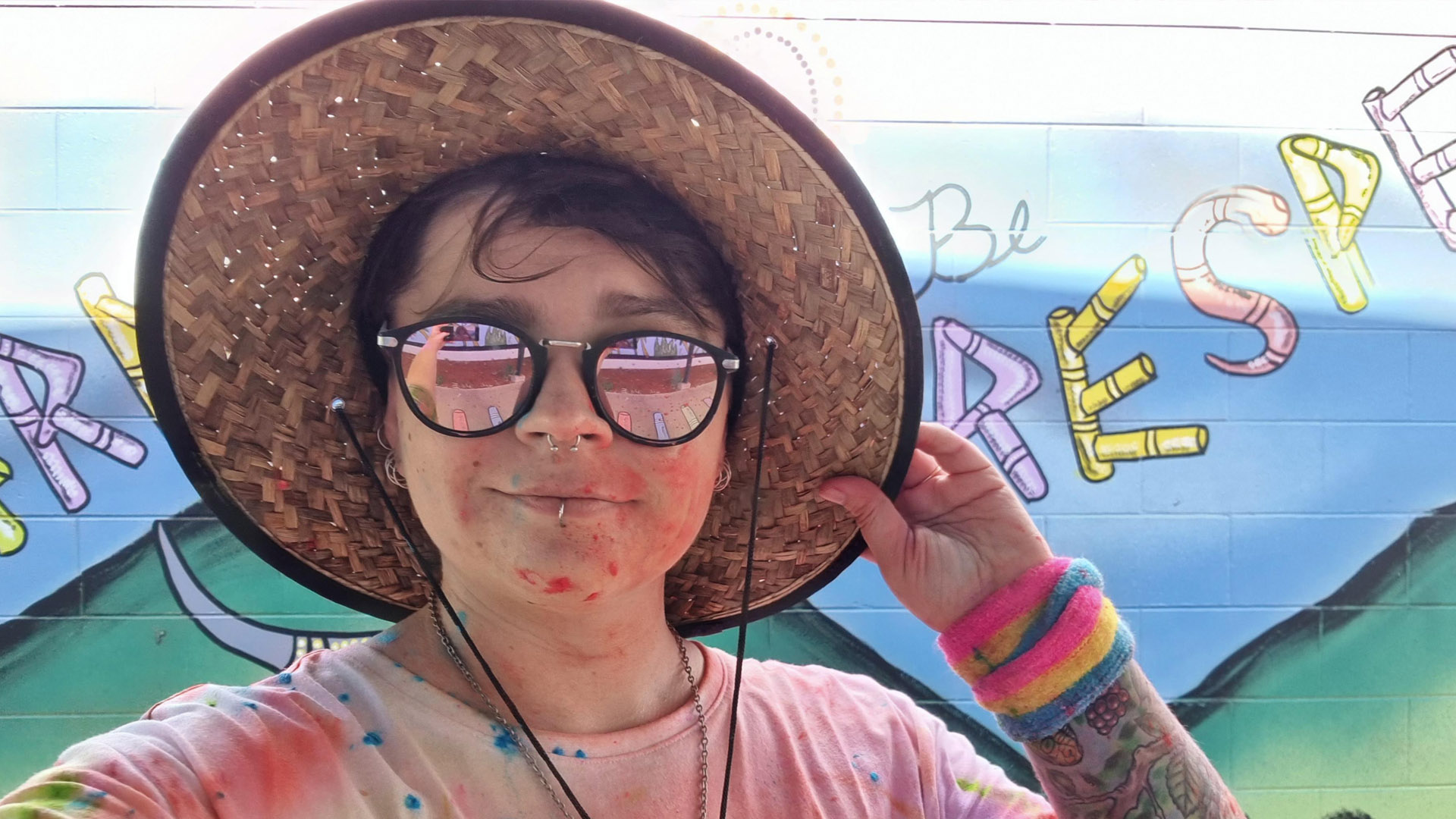 JCU alumni Kit O'Flaherty covered in paint and wearing a hat. 