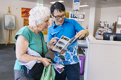 A JCU Social Work student provides advice and an information flyer to a member of the local community. 