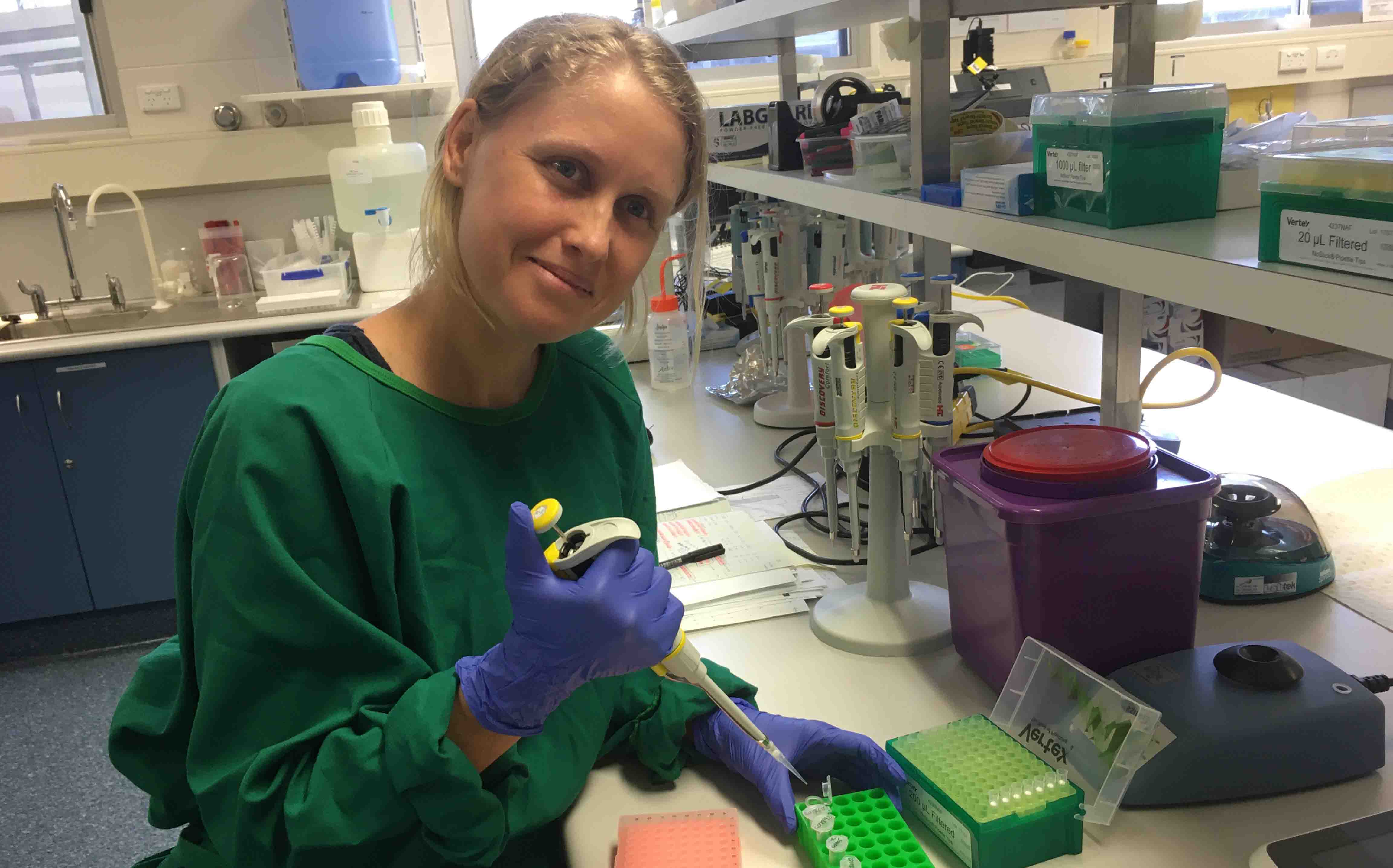 Woman loading samples into test tubes. 