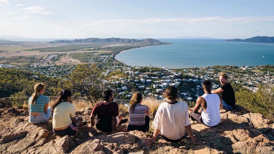 Students sit atop Castle Hill with views of the city, ocean and green landscape.