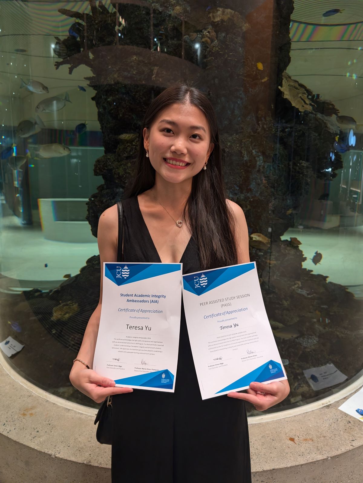 Teresa Yu holding her certificates of appreciation