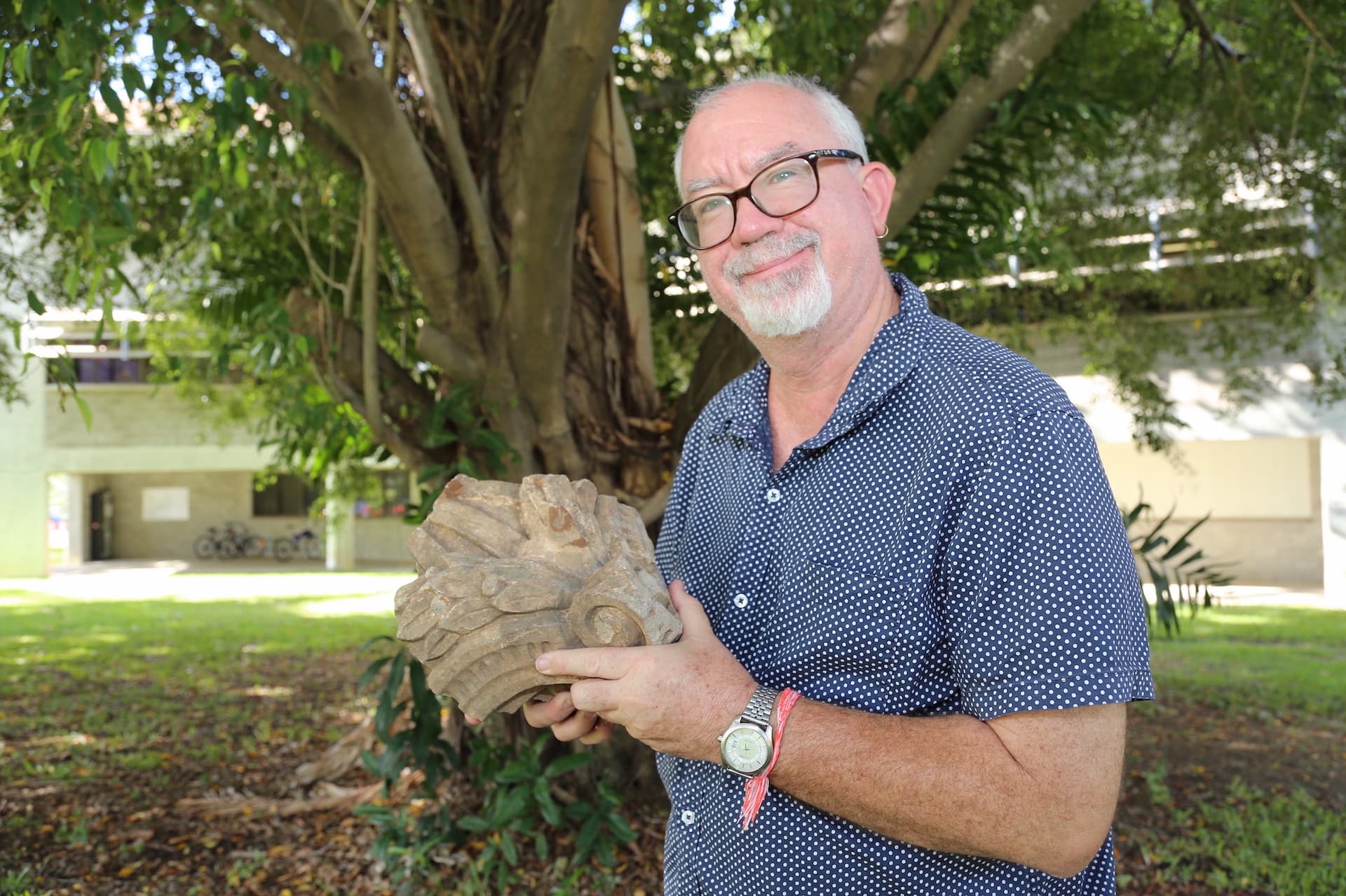 James Cook University archaeology lecturer Dr Nigel Chang with a stonework finial (finishing piece) of Townsville’s Stanton House from the 1880s. The piece was found during excavations at the back of the building.