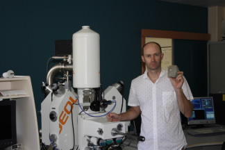Dr Carl Spandler with a rock containing zircon.