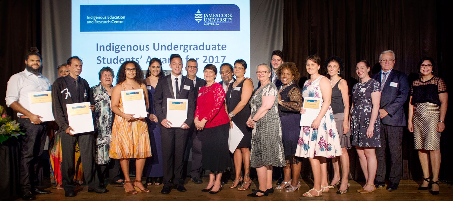 Award winners and JCU staff members pose on stage as a group