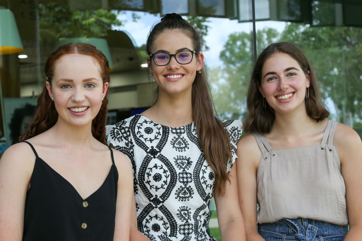 Three young women pose in a line