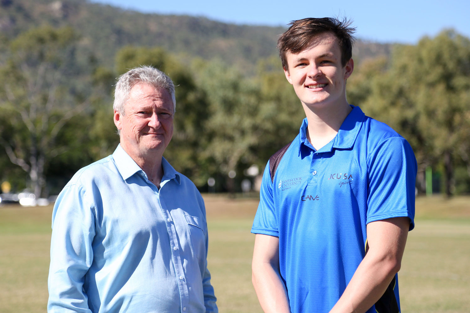 Professor Chris Cocklin and Jake Doran pose for a photo taken outside with Mount Stuart in the background