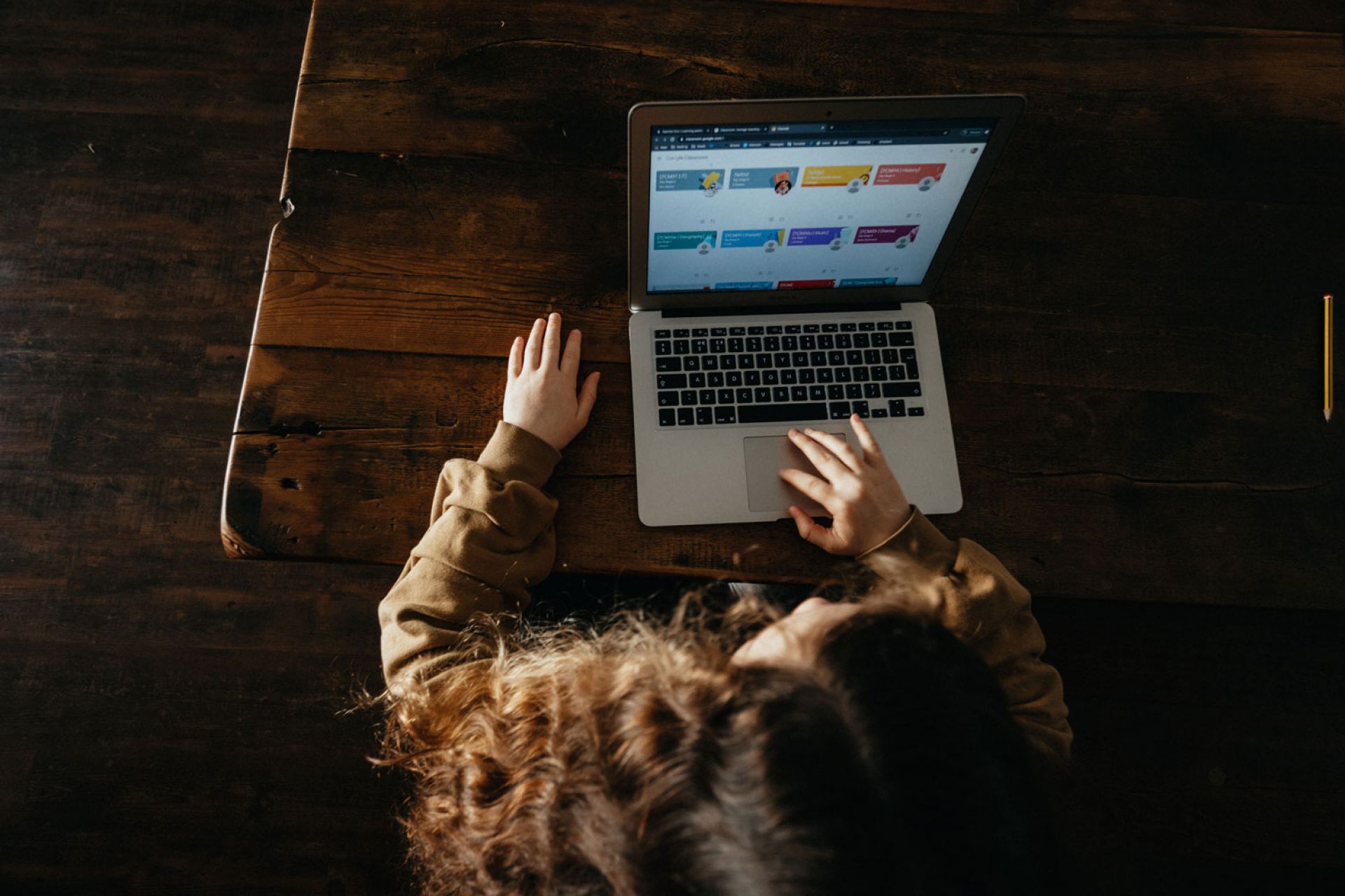 Looking down at a young female working on a laptop 