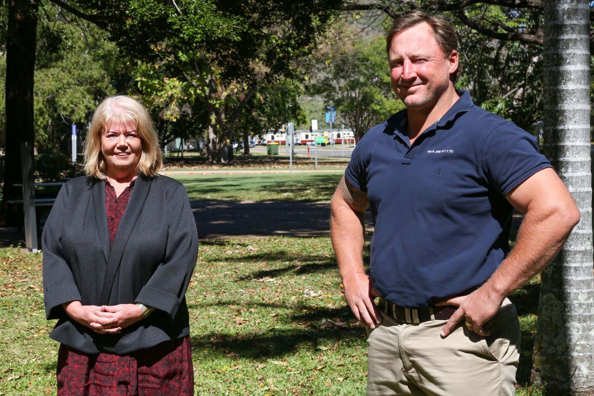 A man and a woman stand outside and pose for the camera