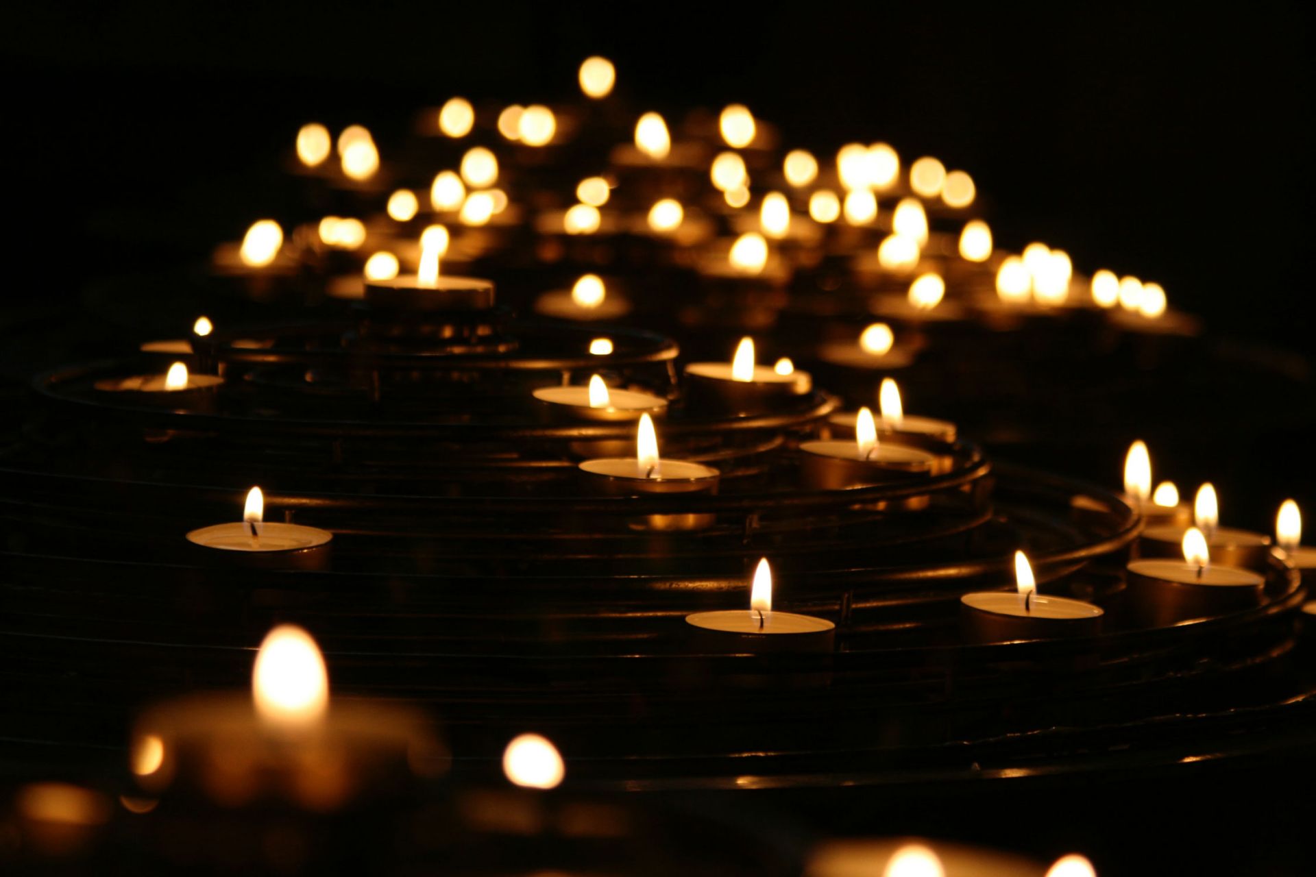 rows of tea candles lit in the dark