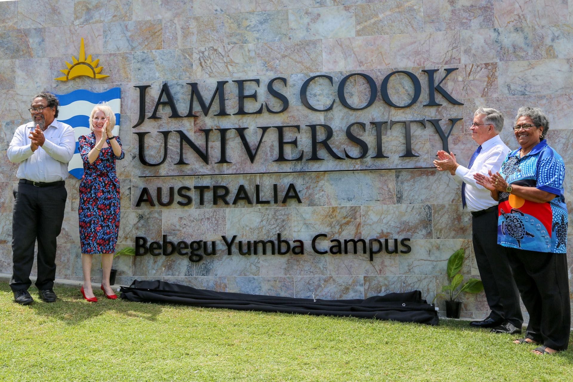 Martin and Sandra stand on the left side, and Bill and Dorothy on the right, of the large JCU marble sign the now includes 