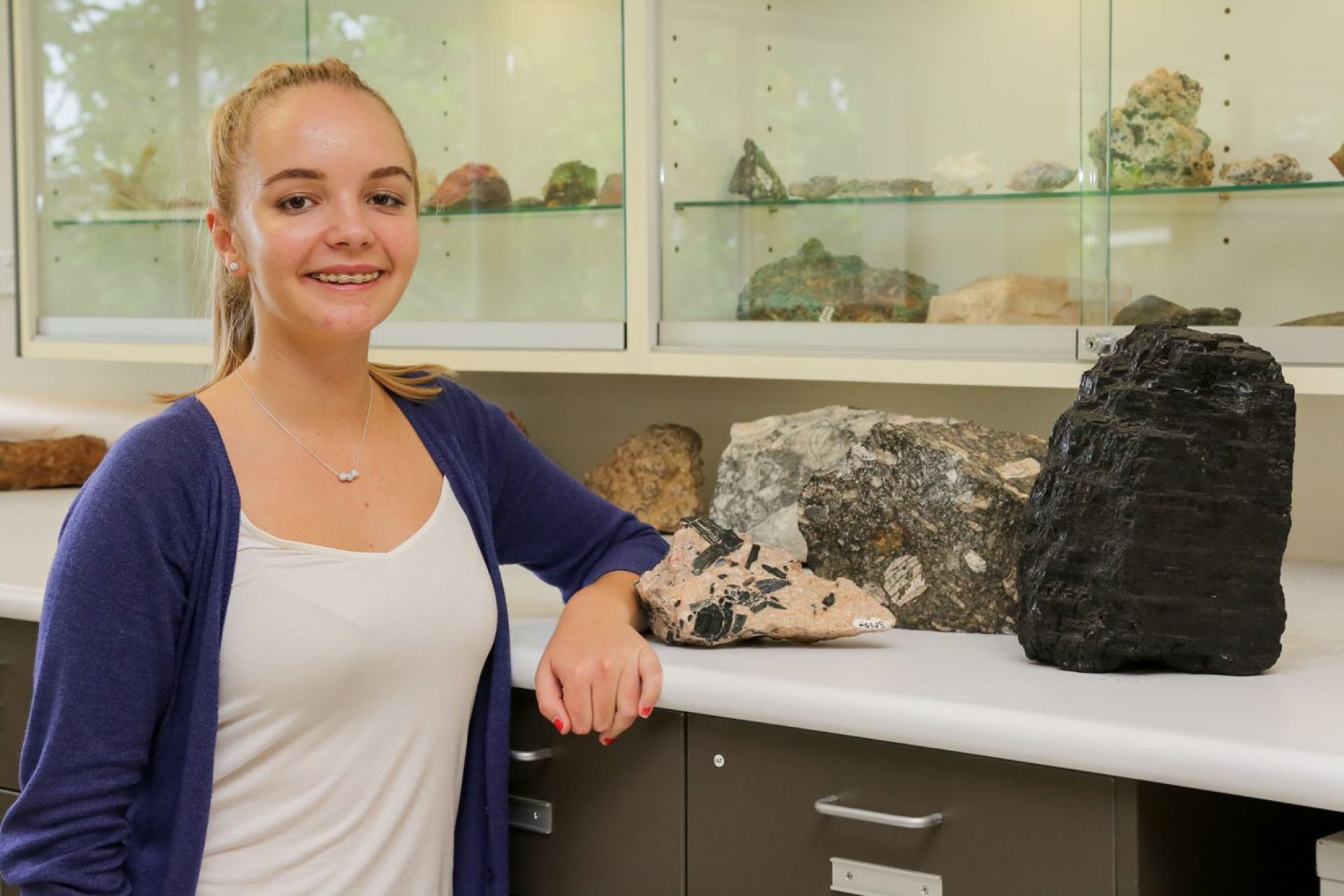 Mistrel stands next to a shelf of assorted rocks
