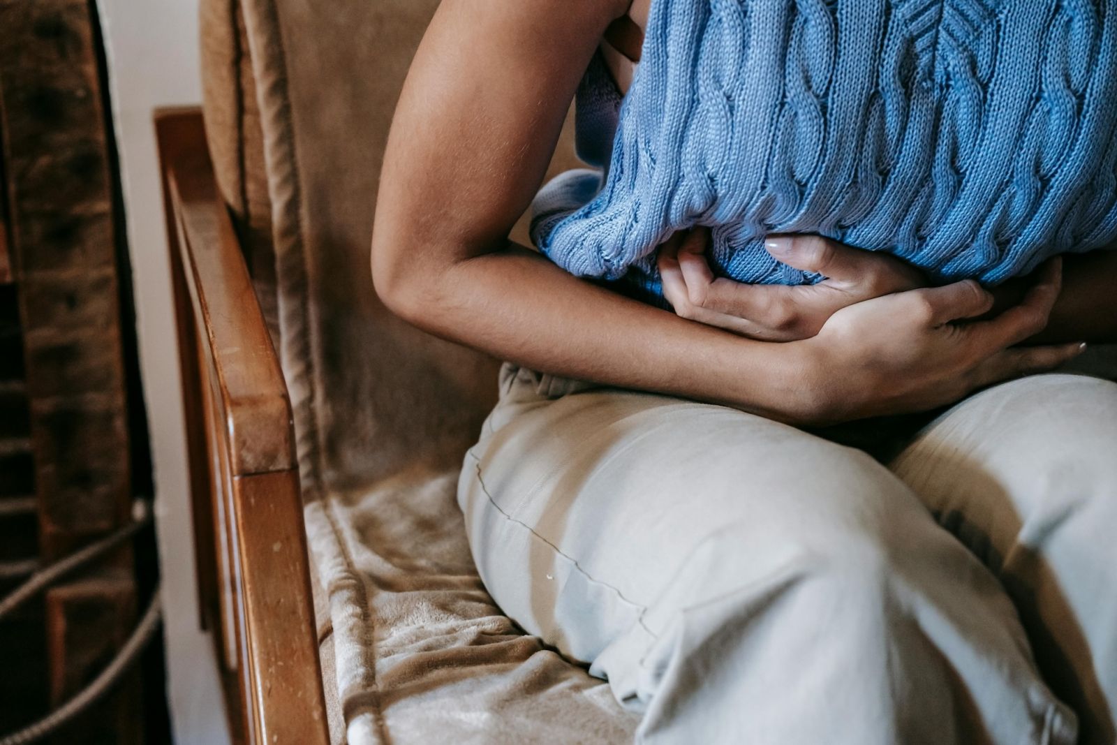 A woman clutching her stomach in pain.