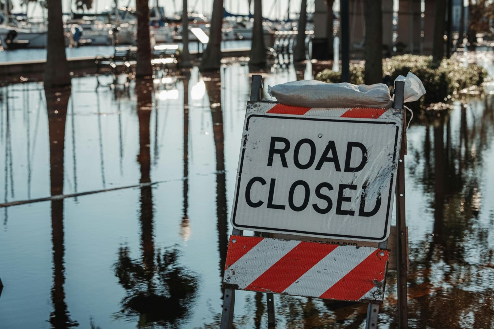 A photo of a flooded road with a road closed sign.