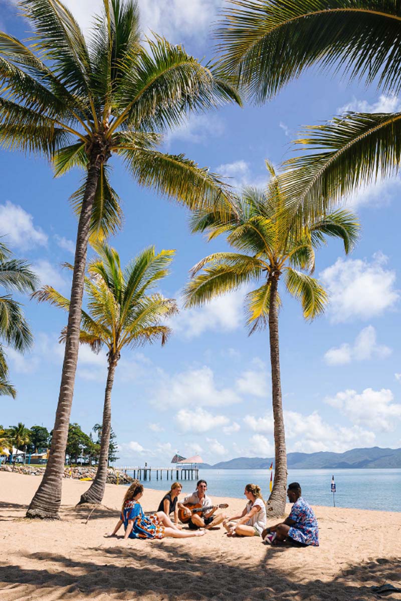 A group of students sitting on a sunny beach in Tropical North Queensland.
