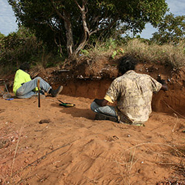 man sitting in river bed. 