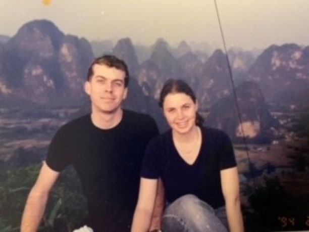 Siblings Richard and Sarah sitting next to each other with mountains in China in background