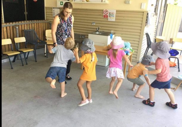 Lara Emmett dancing with young students at school