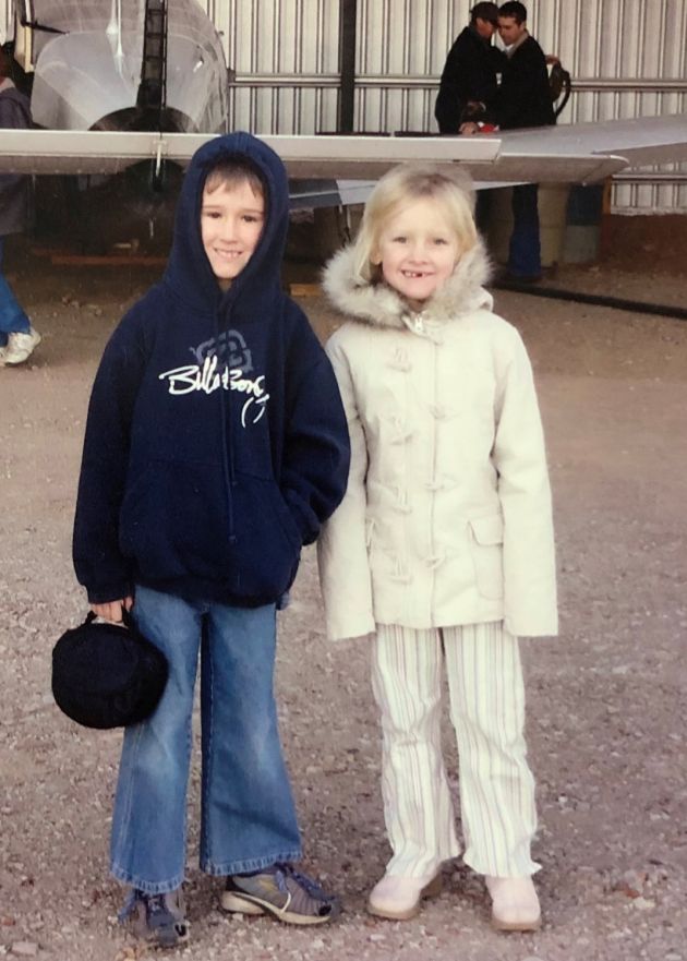 Two young children in front of plane