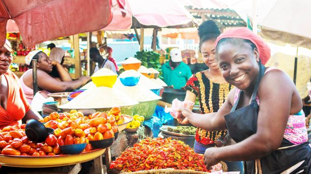 African woman sells vegetables in the marketplace