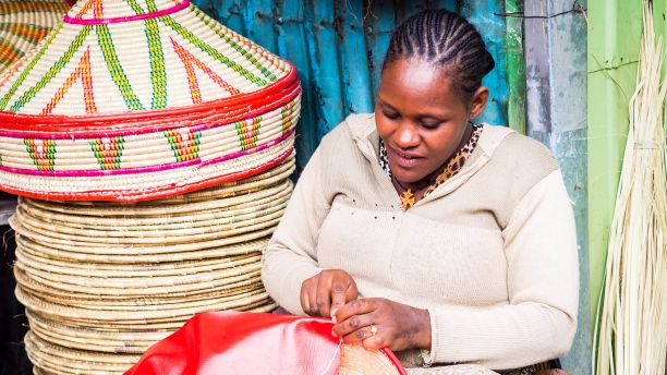 African woman making baskets to sell