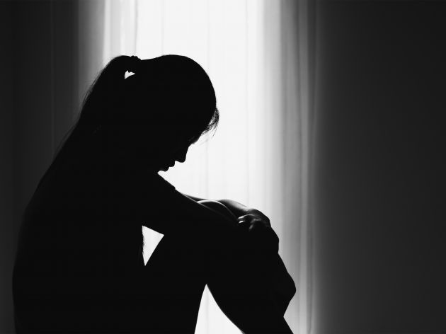An image of a woman in the shadows. 