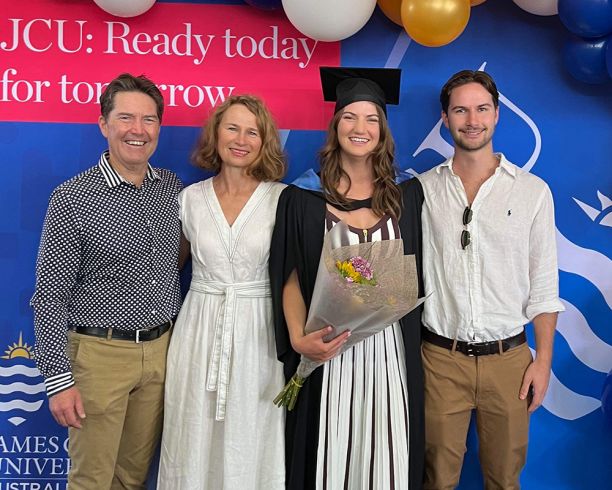 Woman in graduation cap with parents and brother