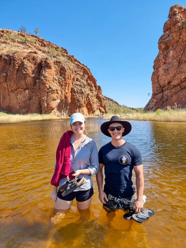young man and woman thigh deep in waterhole 